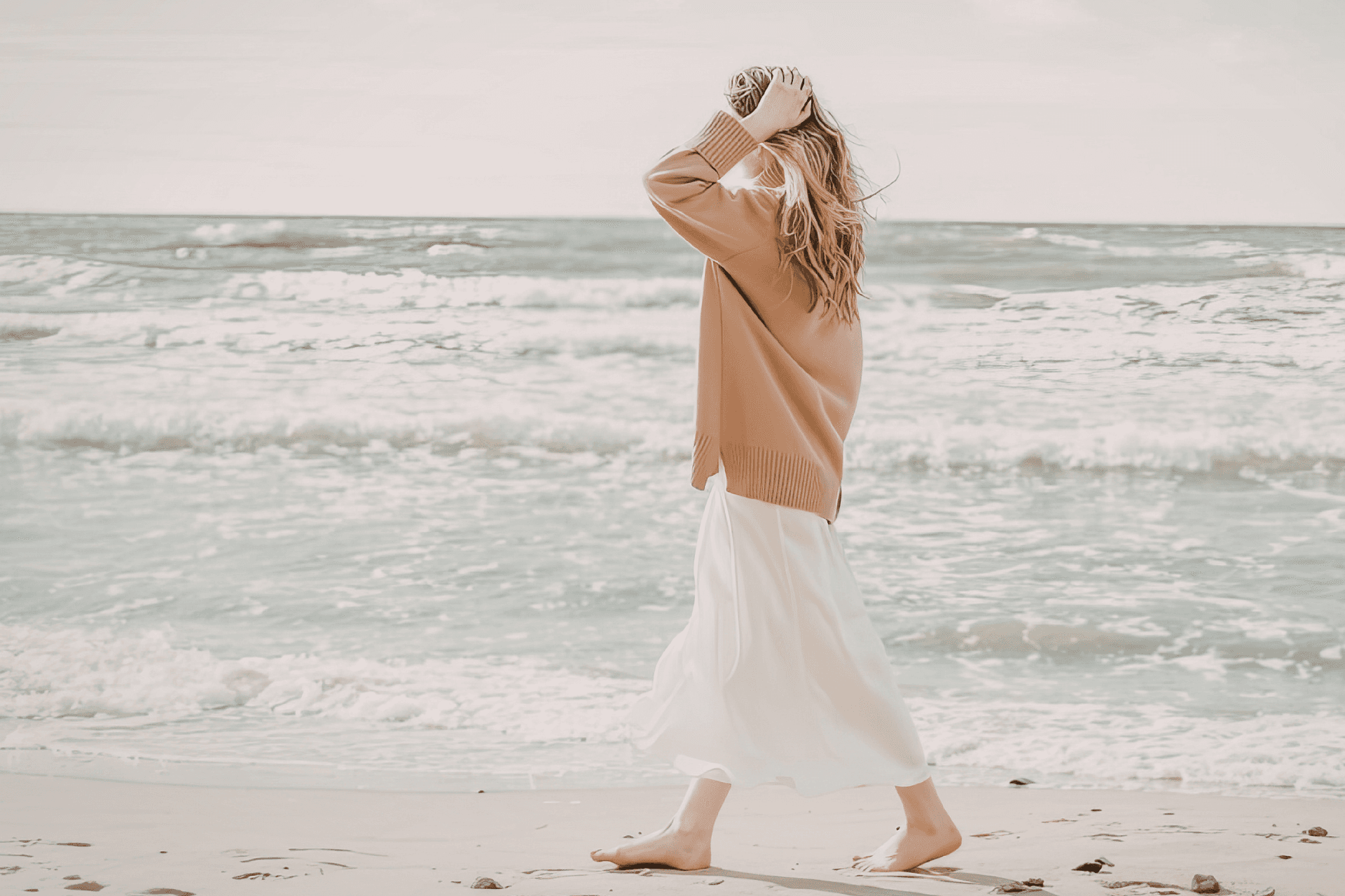 A person walking beside the ocean in a reflective moment